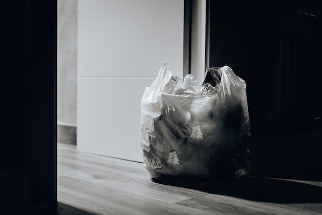 a bag of garbage sitting by a door